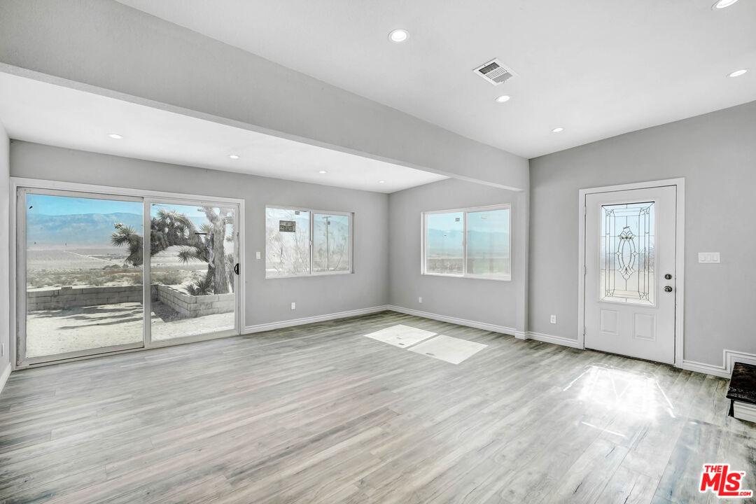 11170 Larkin Road Lucerne Valley, CA 92356 - Photo 5 of 14 an empty room with wooden floor and windows