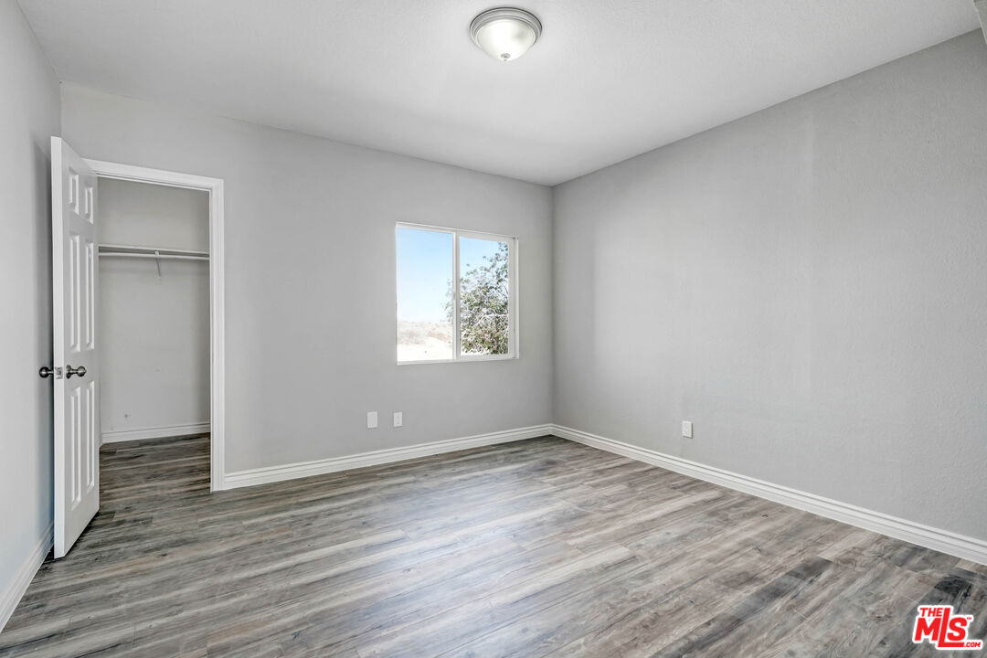 11170 Larkin Road Lucerne Valley, CA 92356 - Photo 10 of 14 wooden floor in an empty room with a window