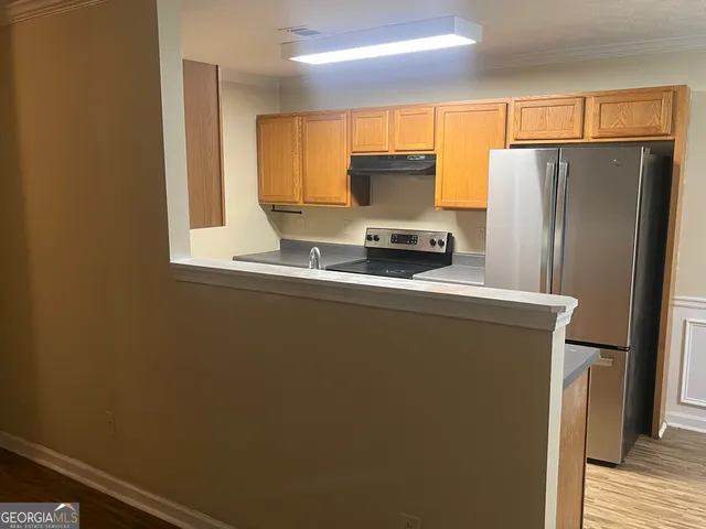 a kitchen with stainless steel appliances a refrigerator and a stove top oven