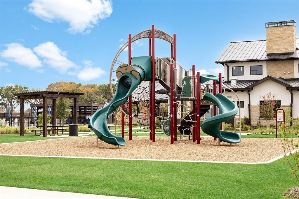 153 Cabrera Street Oak Point, TX 75068 - Photo 20 of 22 Outdoor playground with multiple slides and climbing structures, set on wood chip surfacing