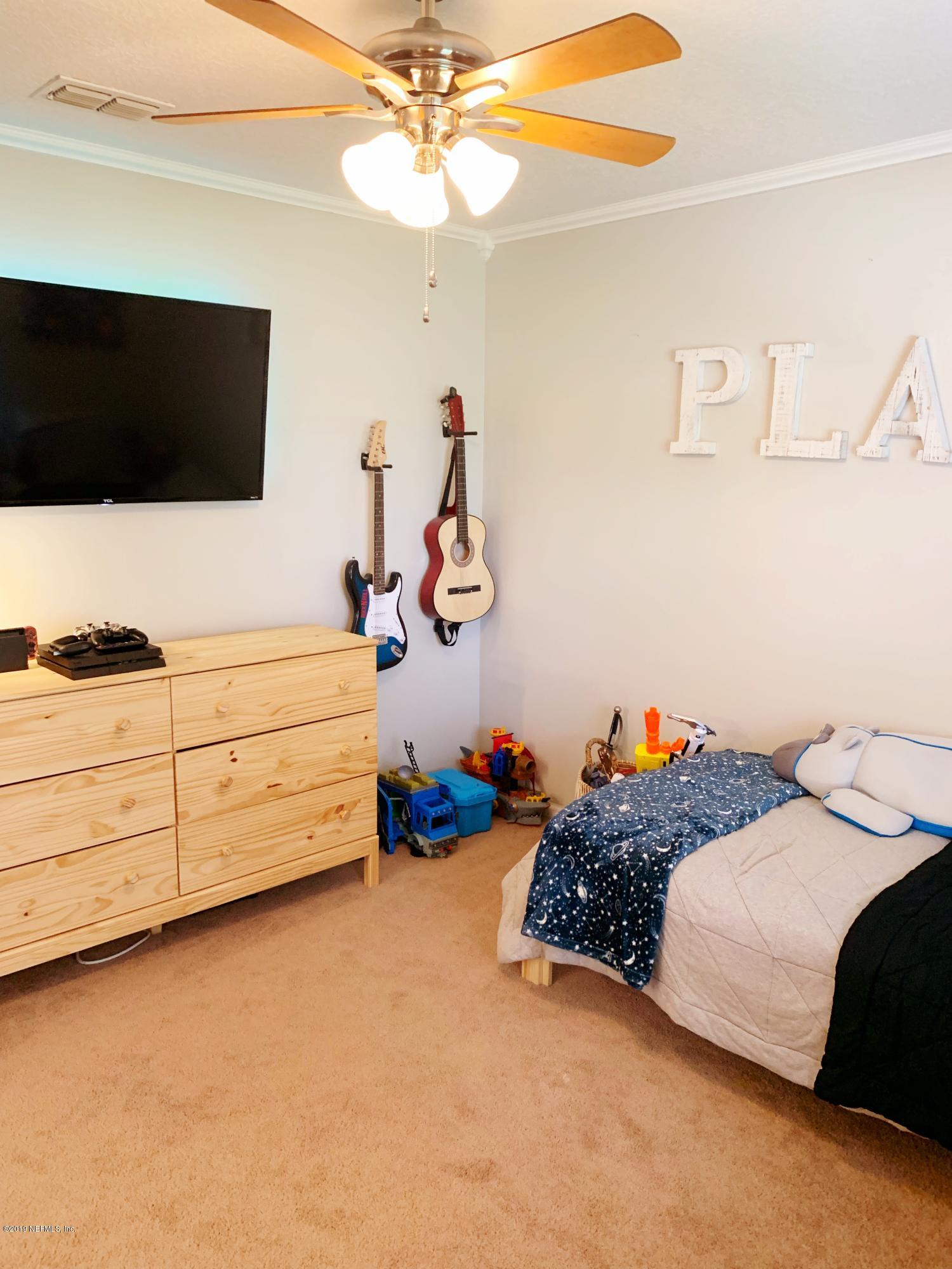 10345 Sugar Grove Road Jacksonville, FL 32221 - Photo 33 of 36 a bedroom with bed and a flat tv screen on dresser