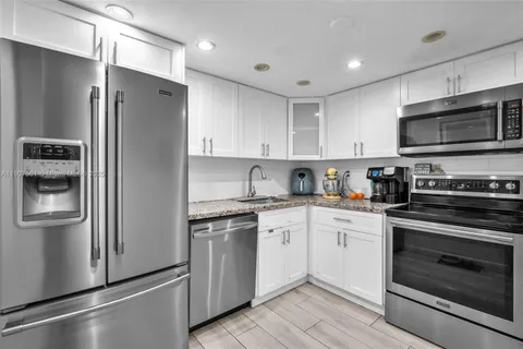 a kitchen with stainless steel appliances granite countertop a refrigerator stove and sink