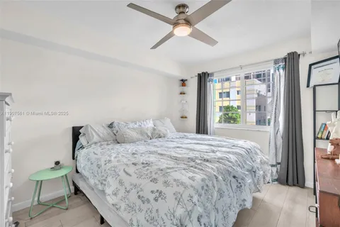 a bedroom with a bed chandelier and a window