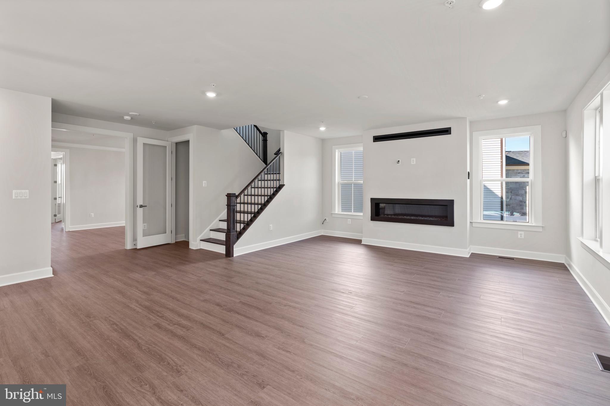 1448 Lavender Cliff Way Odenton, MD 21113 - Photo 25 of 94 an empty room with wooden floor staircase and windows