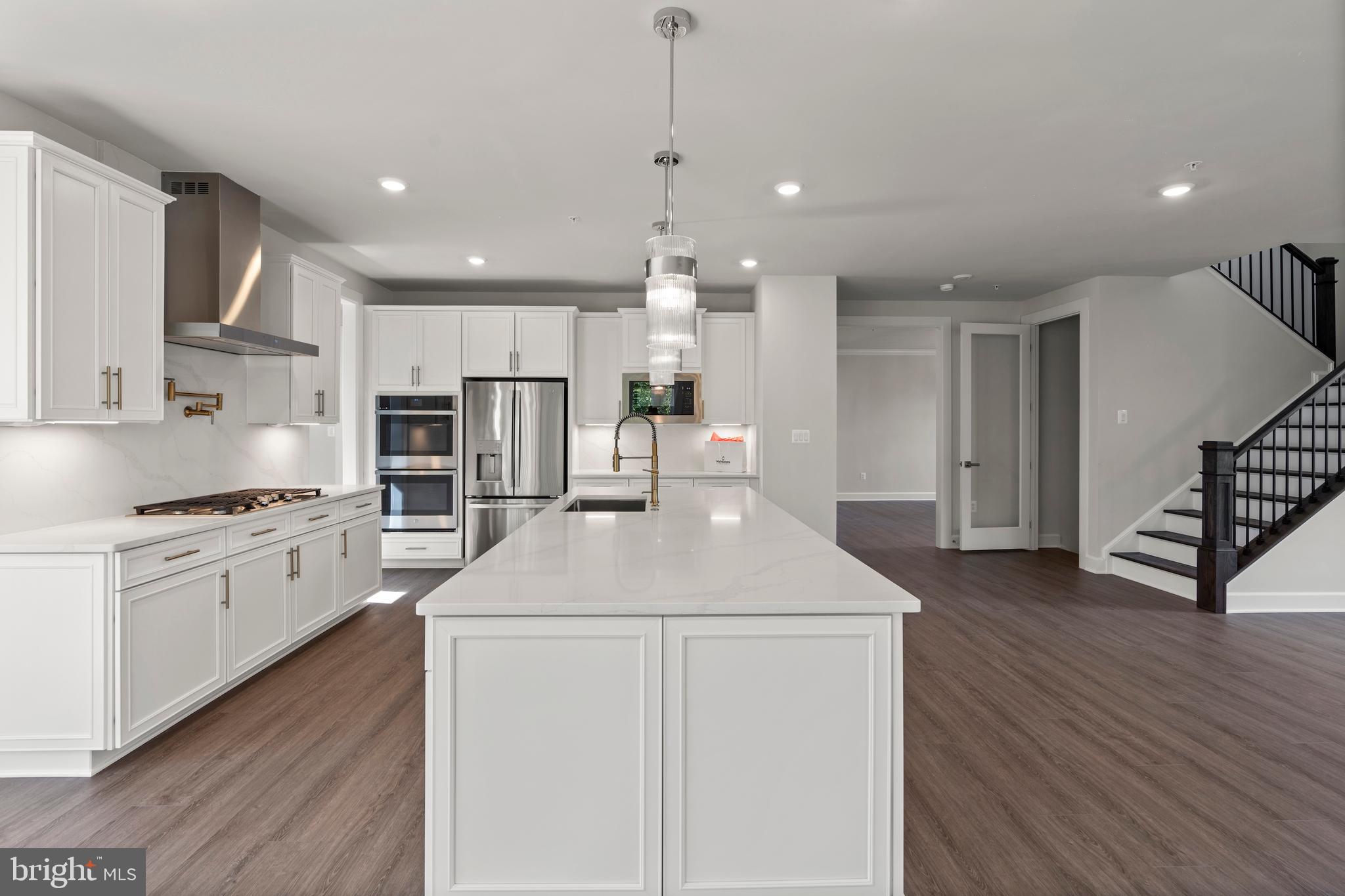 1448 Lavender Cliff Way Odenton, MD 21113 - Photo 26 of 94 a kitchen with stainless steel appliances kitchen island wooden floors granite counter tops and white cabinets