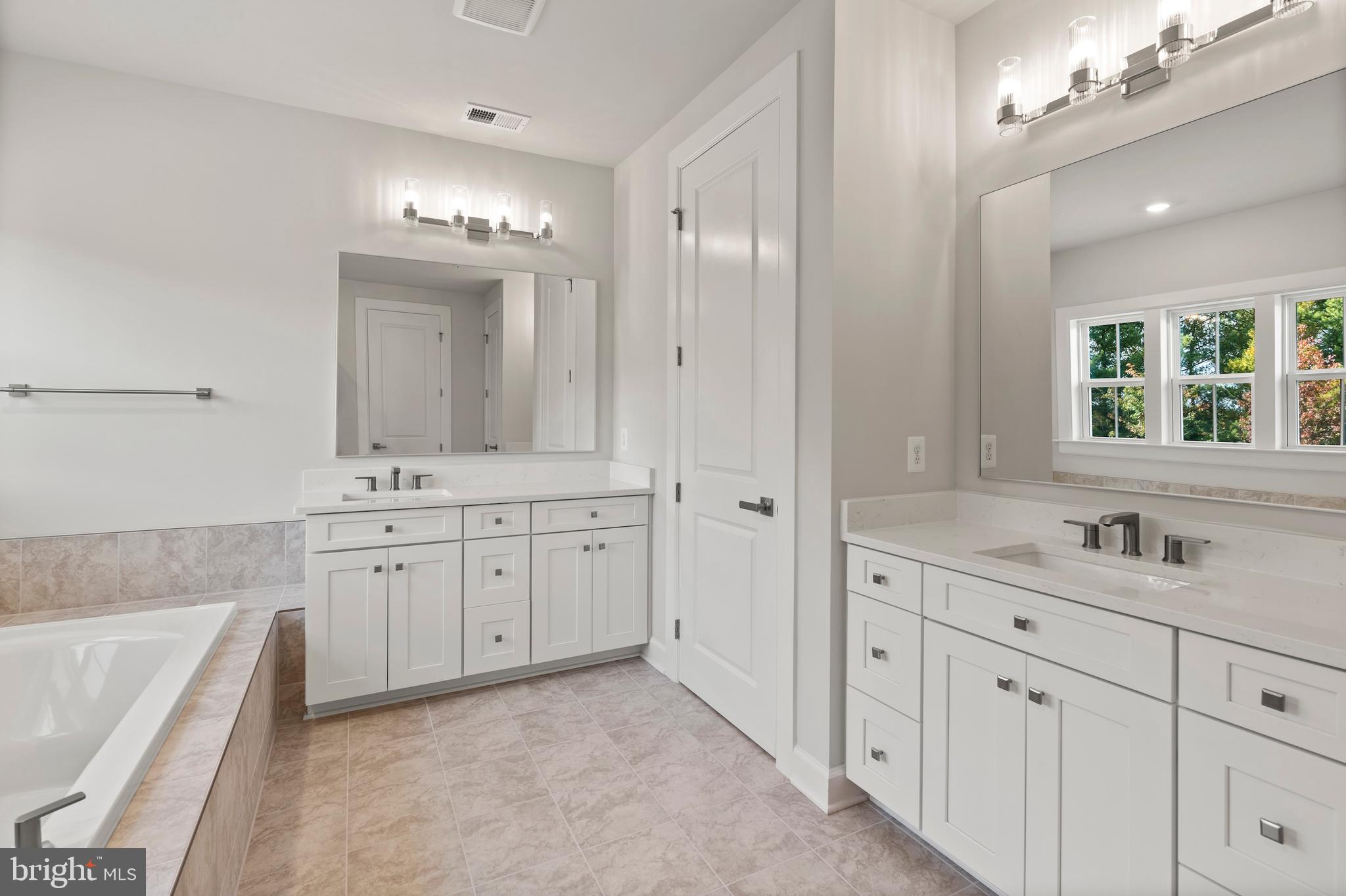 1448 Lavender Cliff Way Odenton, MD 21113 - Photo 88 of 94 a spacious bathroom with double vanity a mirror a bathtub and a double vanity sink