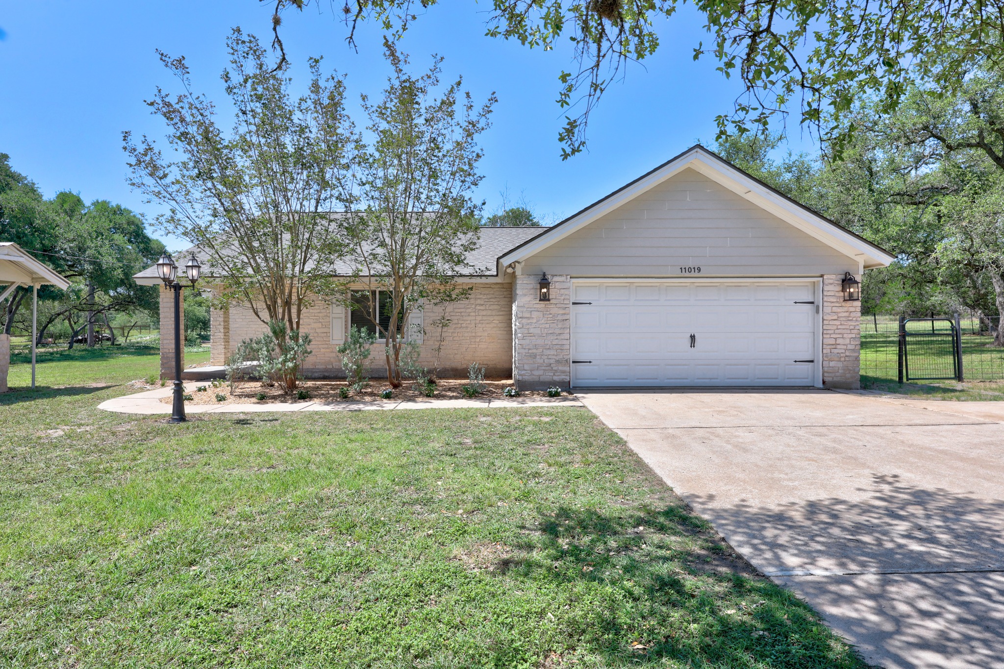 11019 Southwest Oaks Austin, TX 78737 - Photo 2 of 39 An extended driveway leads you to the charming single-story home.