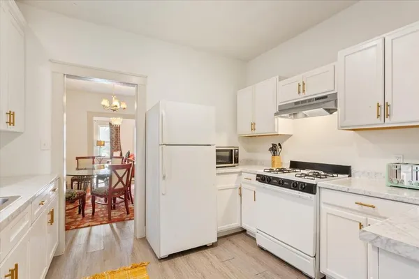 a kitchen with white cabinets and appliances