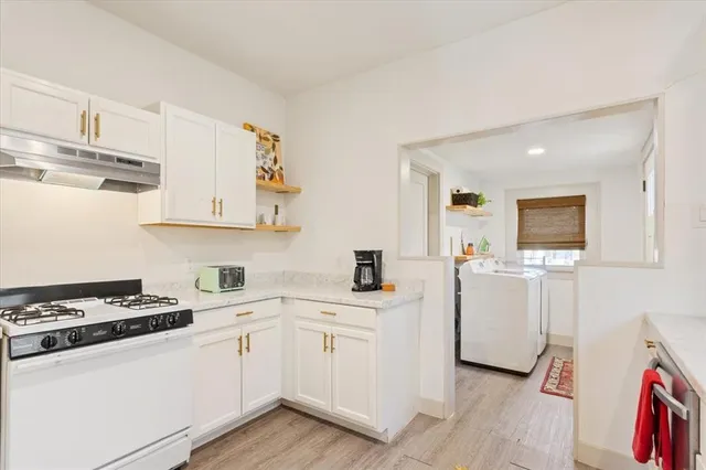 a kitchen with cabinets stainless steel appliances and wooden floor