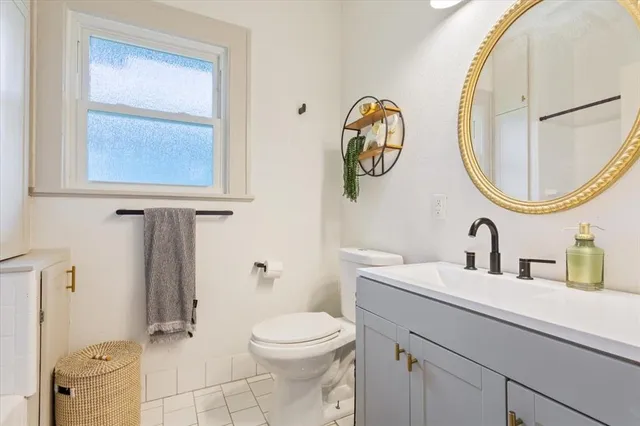 a bathroom with a toilet a sink and mirror