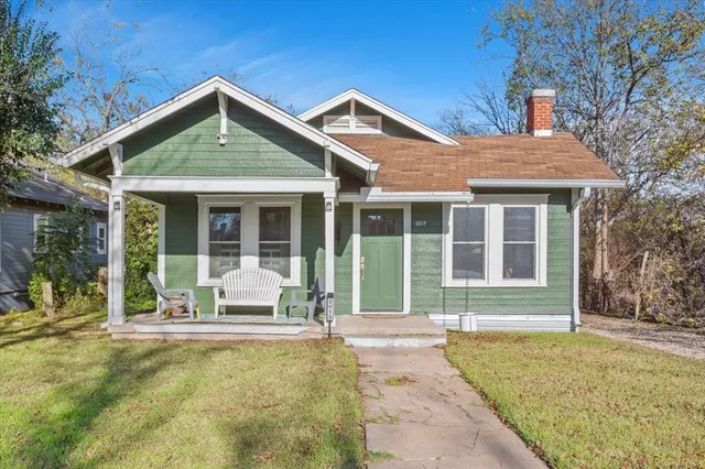 a front view of a house with a yard and outdoor seating