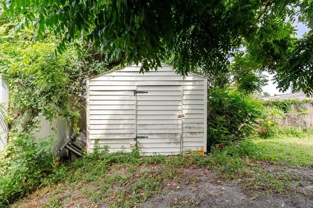 an aerial view of residential houses with outdoor space and trees