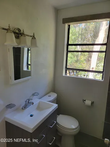 a bathroom with a sink a toilet and a mirror
