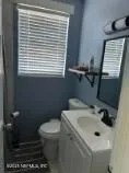 a bathroom with a sink a toilet and a window