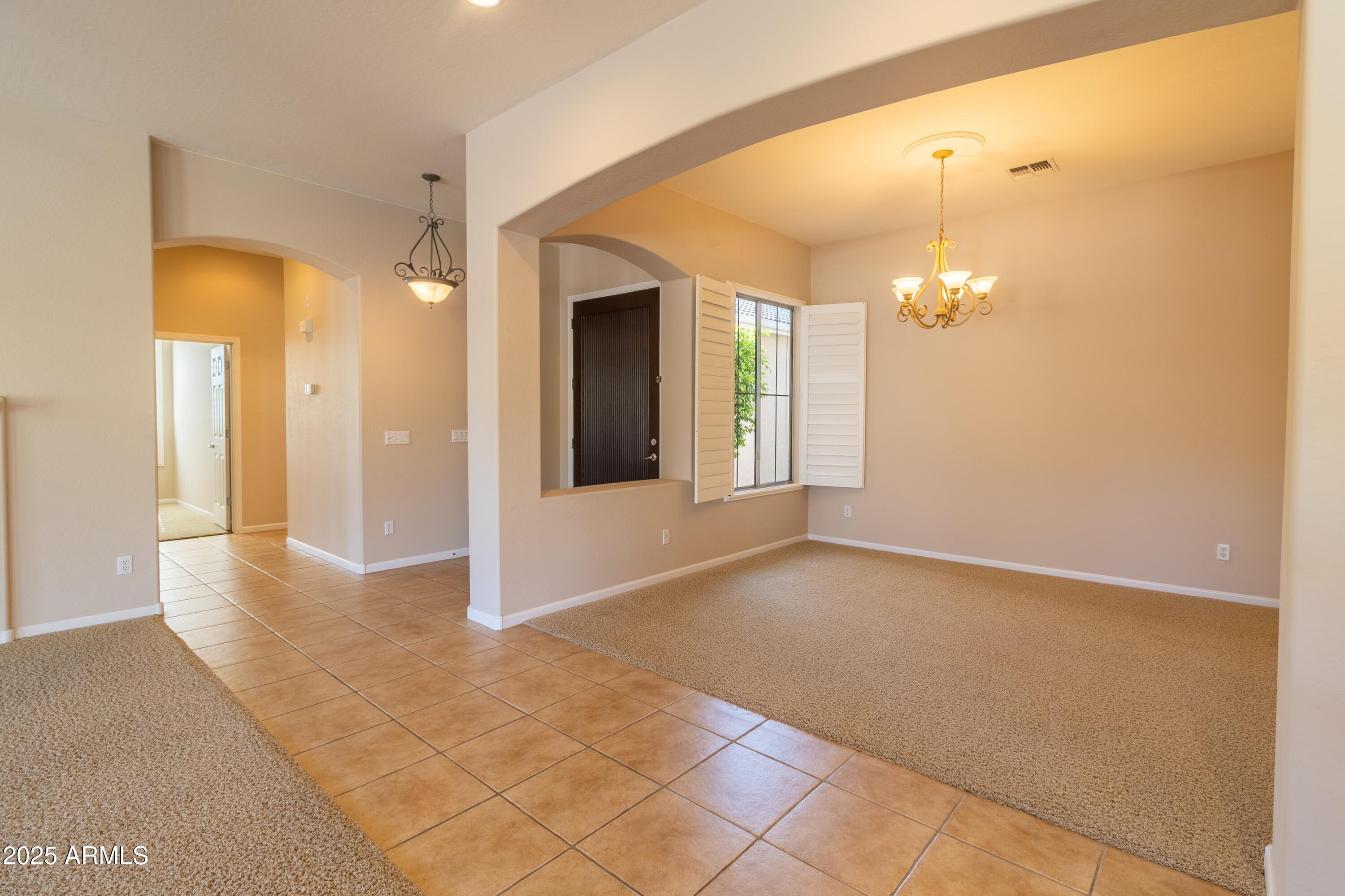 4241 East Andre Avenue Gilbert, AZ 85298 - Photo 7 of 39 a view of a hallway with wooden floor and chandelier