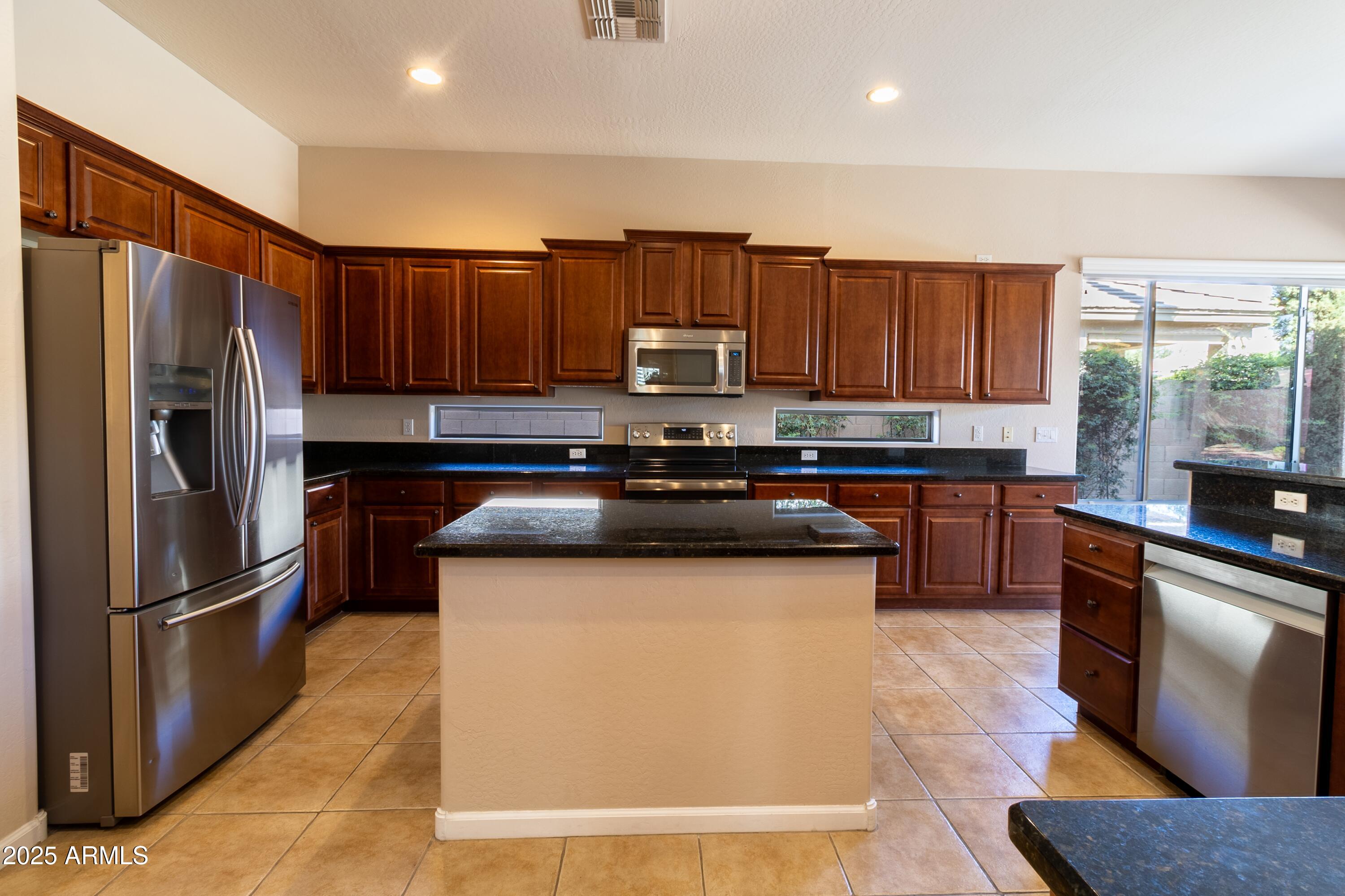 4241 East Andre Avenue Gilbert, AZ 85298 - Photo 9 of 39 a kitchen with stainless steel appliances granite countertop a refrigerator sink and stove