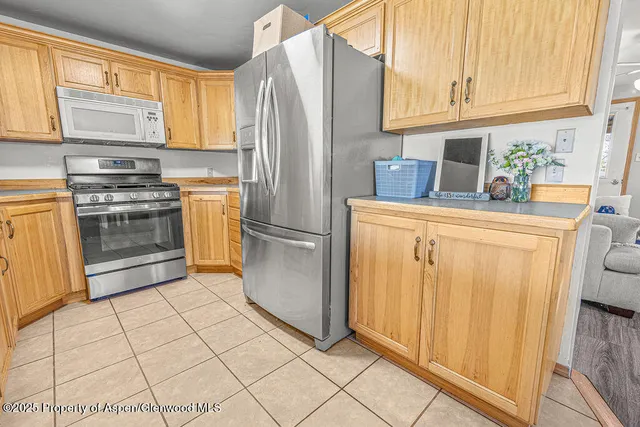 a kitchen with stainless steel appliances granite countertop a stove a sink a microwave and a refrigerator