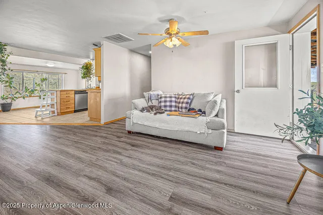 a view of a livingroom with furniture wooden floor and a large window