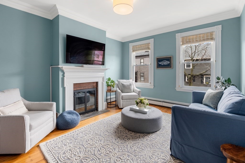 a living room with furniture a flat screen tv and a fireplace