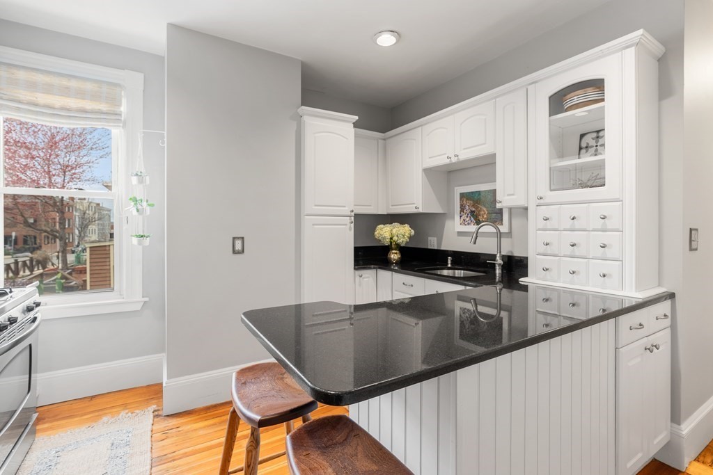 87 High Street, Unit 1 Boston, MA 02129 - Photo 3 of 18 a kitchen with kitchen island a large window appliances and a counter space