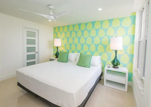 a large bed sitting in a bedroom next to a window