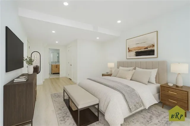 a bedroom with bed and a painting on the wall