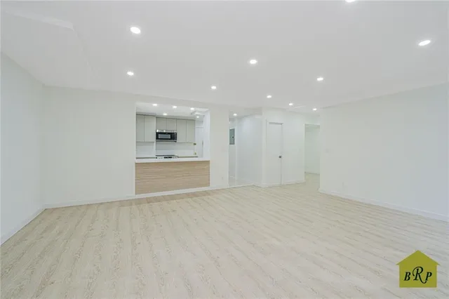 a view of large kitchen with a sink and dishwasher a refrigerator with white cabinets