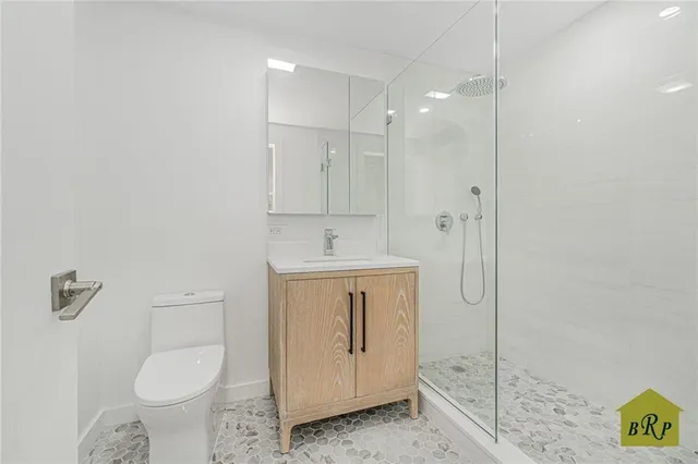 a bathroom with a granite countertop toilet sink and mirror