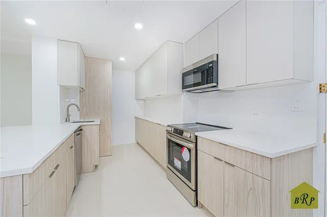 a kitchen with stainless steel appliances white cabinets and a sink