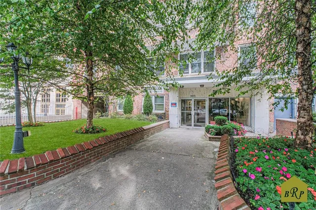 a front view of a house with a yard and a garden