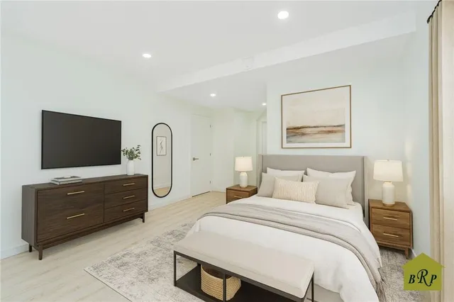 a spacious bedroom with a bed and a flat screen tv