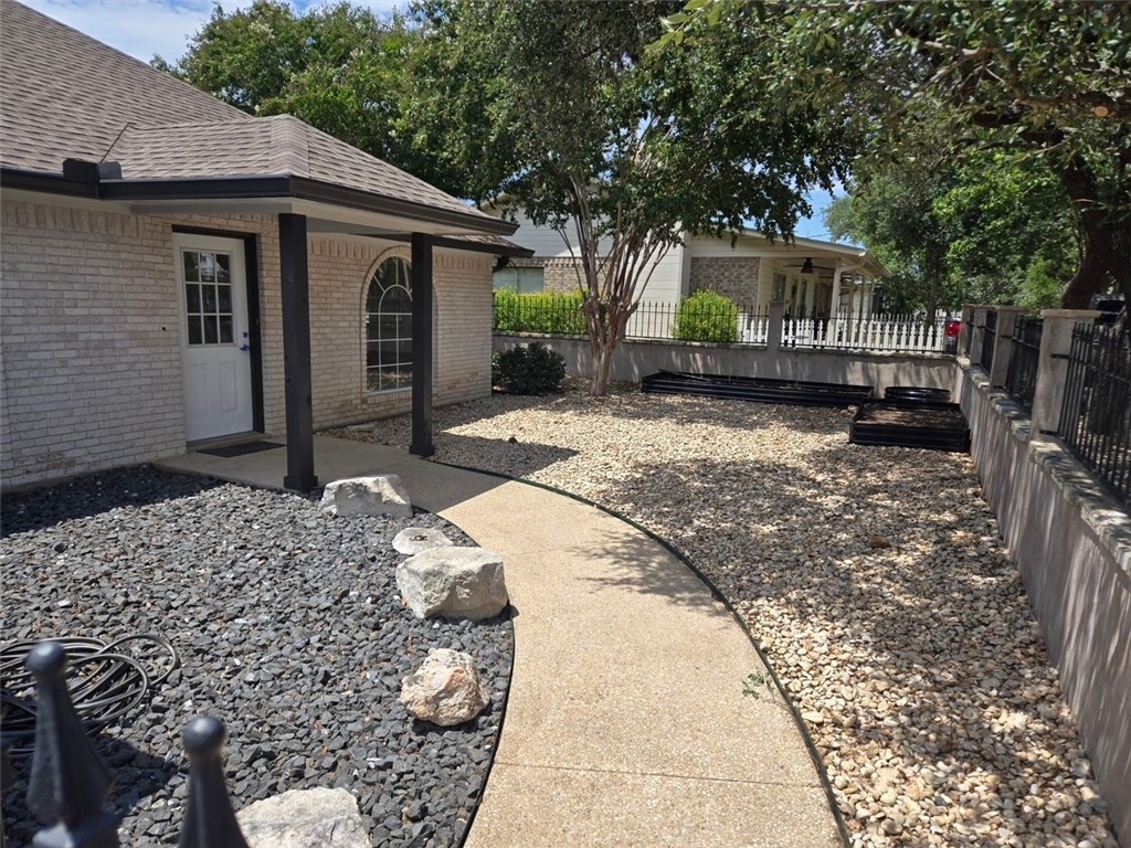 1132 Fifth Street Comfort, TX 78013 - Photo 3 of 20 a backyard of a house with large trees and wooden fence