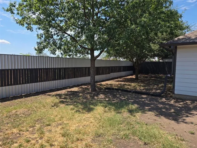 a kitchen with granite countertop a stove a sink and a refrigerator
