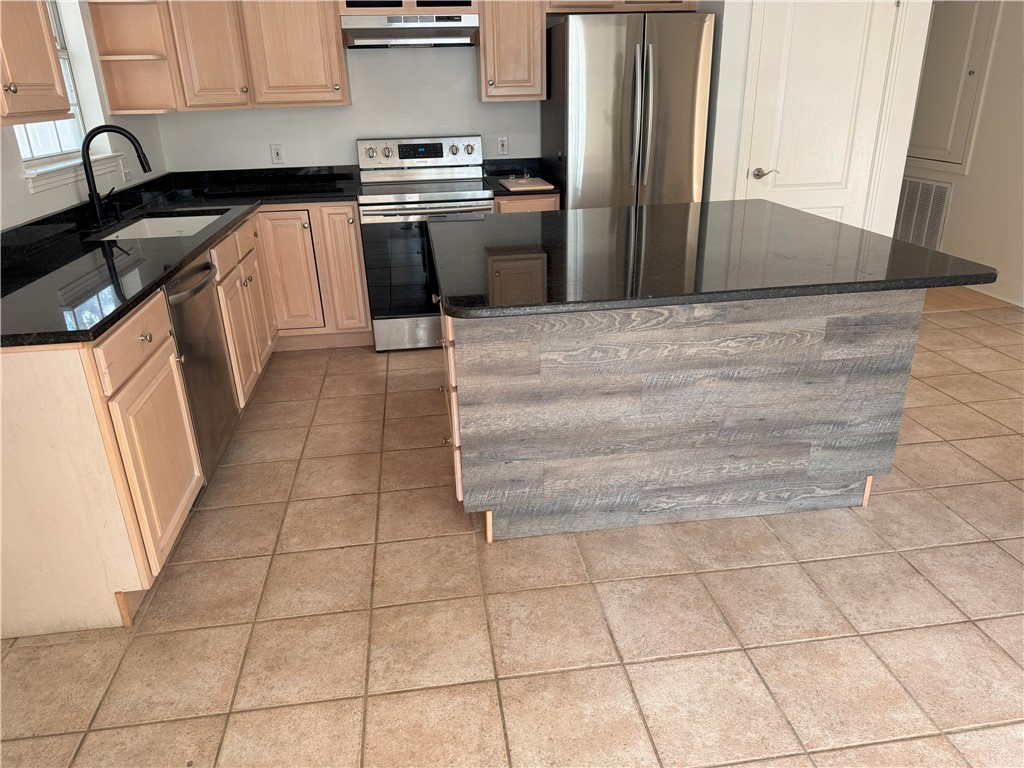 1132 Fifth Street Comfort, TX 78013 - Photo 7 of 20 a kitchen with granite countertop a stove a sink and a refrigerator
