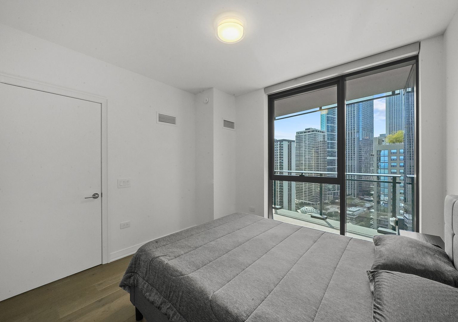 211 North Harbor Drive, Unit 2203 Chicago, IL 60601 - Photo 23 of 56 a bedroom with a large bed and a large window