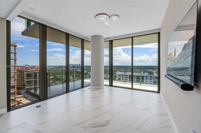 a view of an empty room with a window and a chandelier