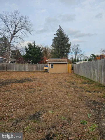 a view of a yard with wooden fence