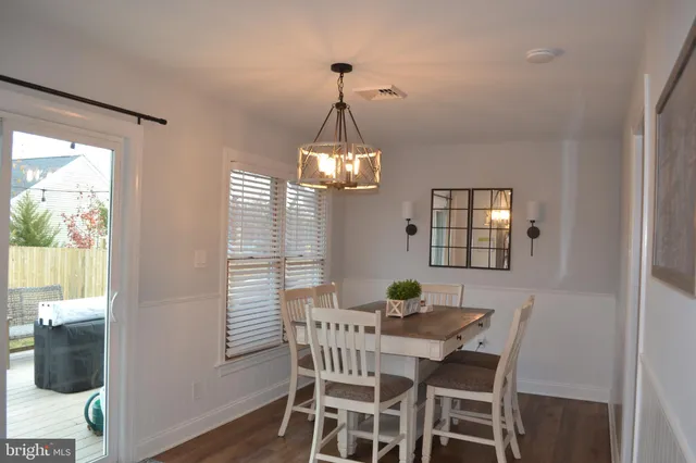 a dining room with furniture a chandelier and wooden floor