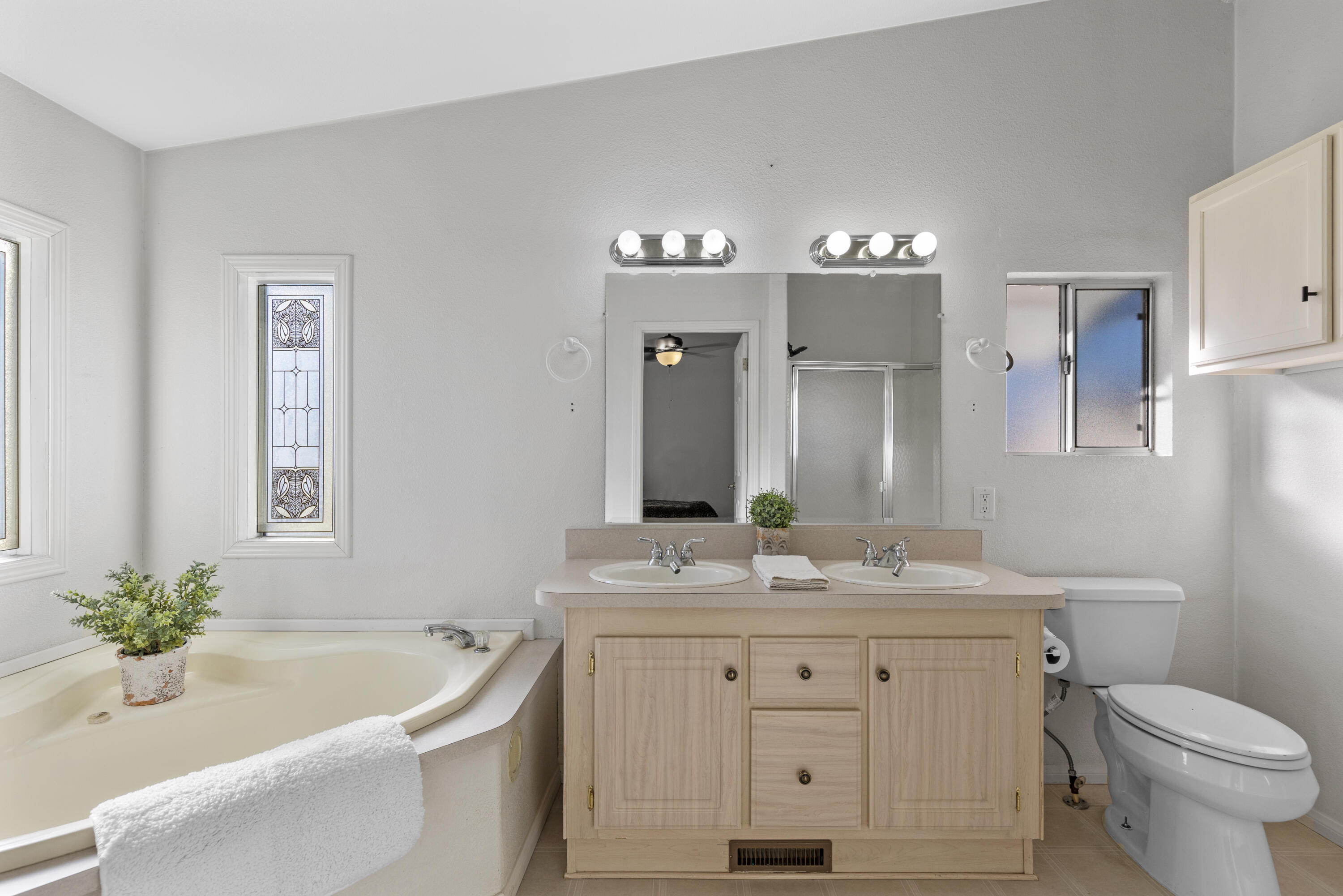 14556 East Tehachapi Boulevard Tehachapi, CA 93561 - Photo 14 of 23 a bathroom with a granite countertop sink a toilet a large mirror a bathtub and shower