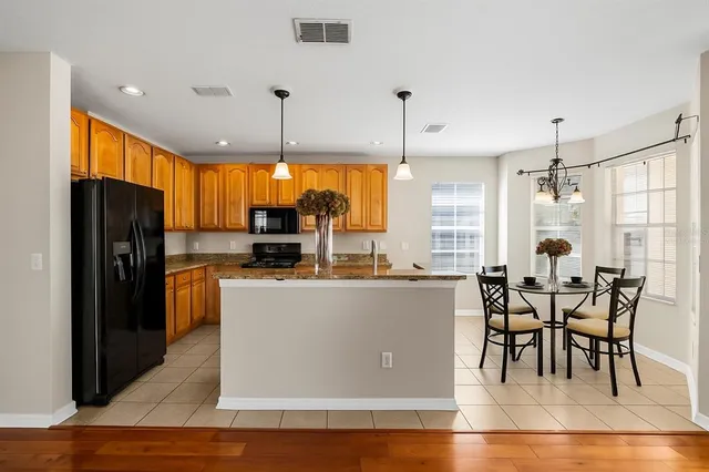 a kitchen with stainless steel appliances granite countertop a stove a sink and a refrigerator