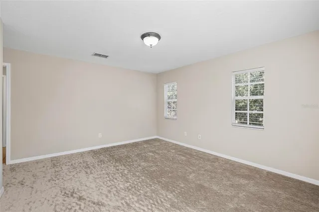 an empty room with a window and a fan