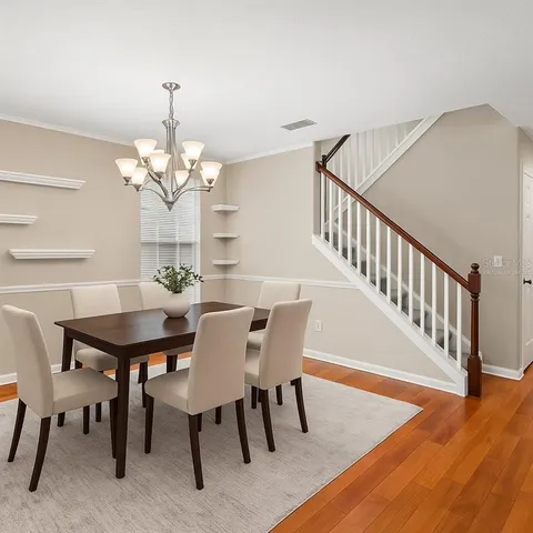 a view of a livingroom with wooden floor and a chandelier