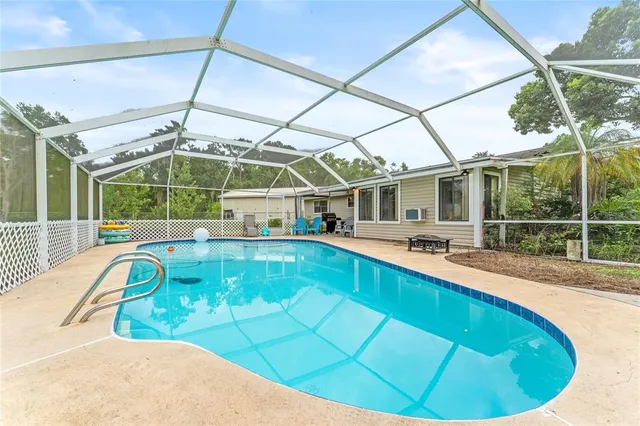 a view of a swimming pool with a patio and yard of the house