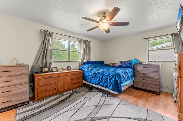 a living room with a bed dresser and a window