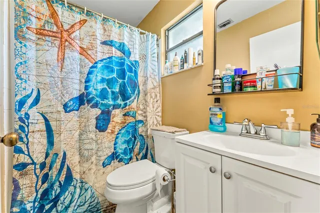 a bathroom with a sink mirror vanity and toilet