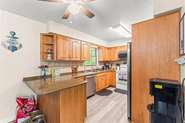 a kitchen with a sink appliances cabinets and a window