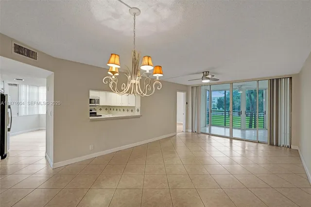 a view of a livingroom with a chandelier fan and windows