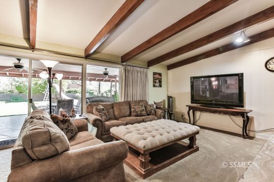 1509 Welcome Way Ridgecrest, CA 93555 - Photo 24 of 50 a living room with furniture a flat screen tv and a floor to ceiling window