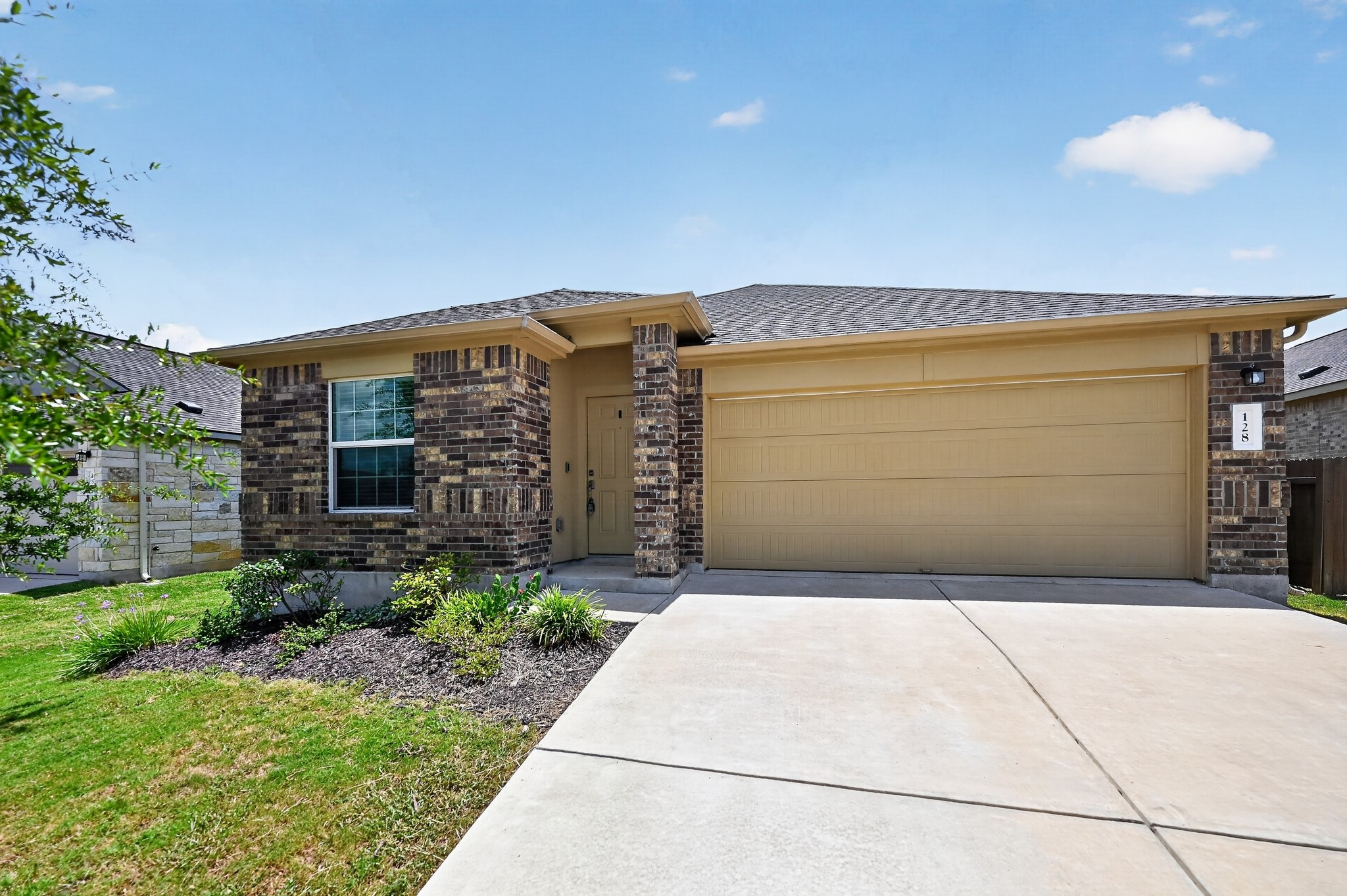128 Konik Road Georgetown, TX 78626 - Photo 1 of 34 A well-maintained facade with brick accents and an attached garage offers inviting curb appeal.
