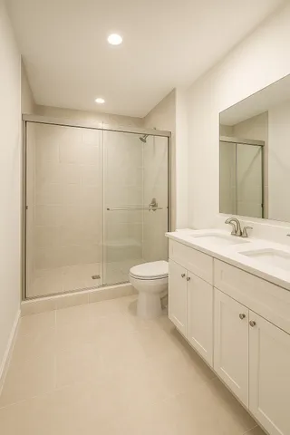 a bathroom with a double vanity sink toilet and shower
